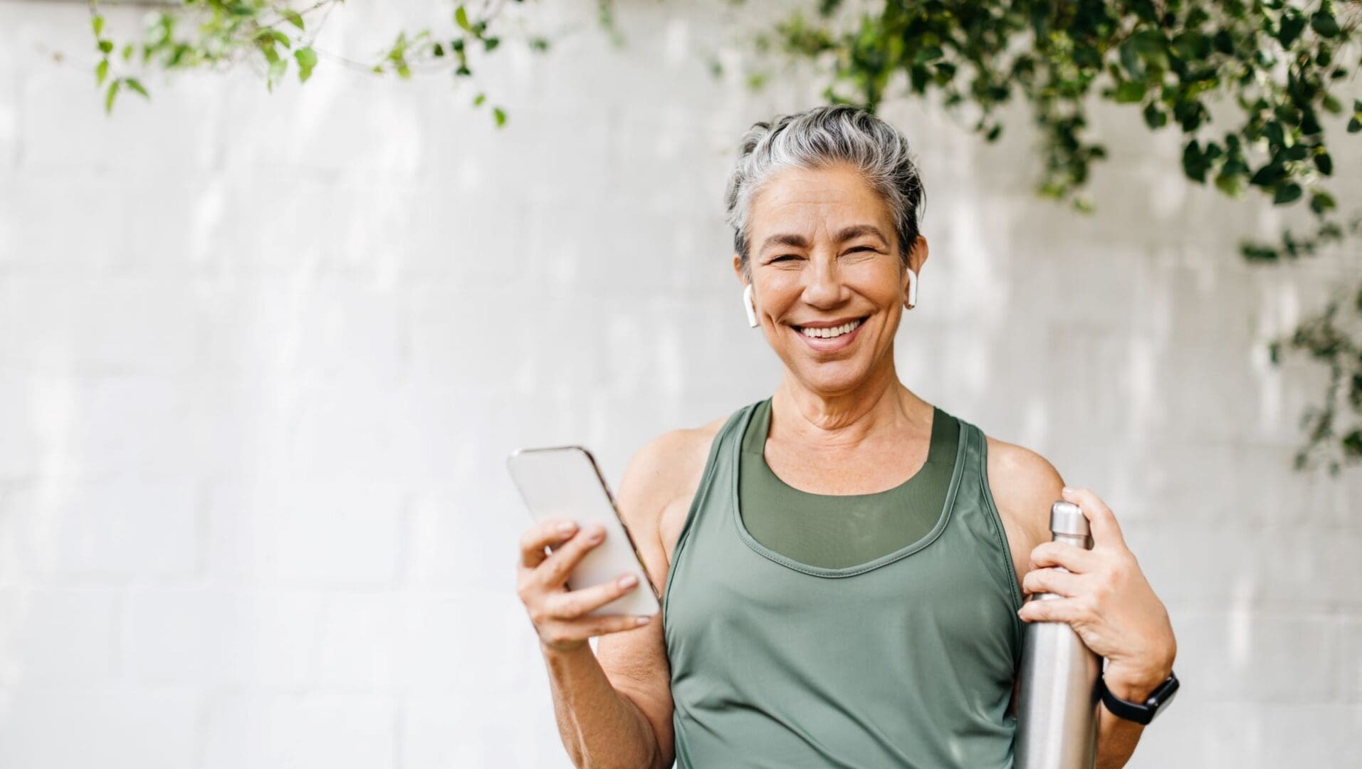 A woman holding a phone and smiling.