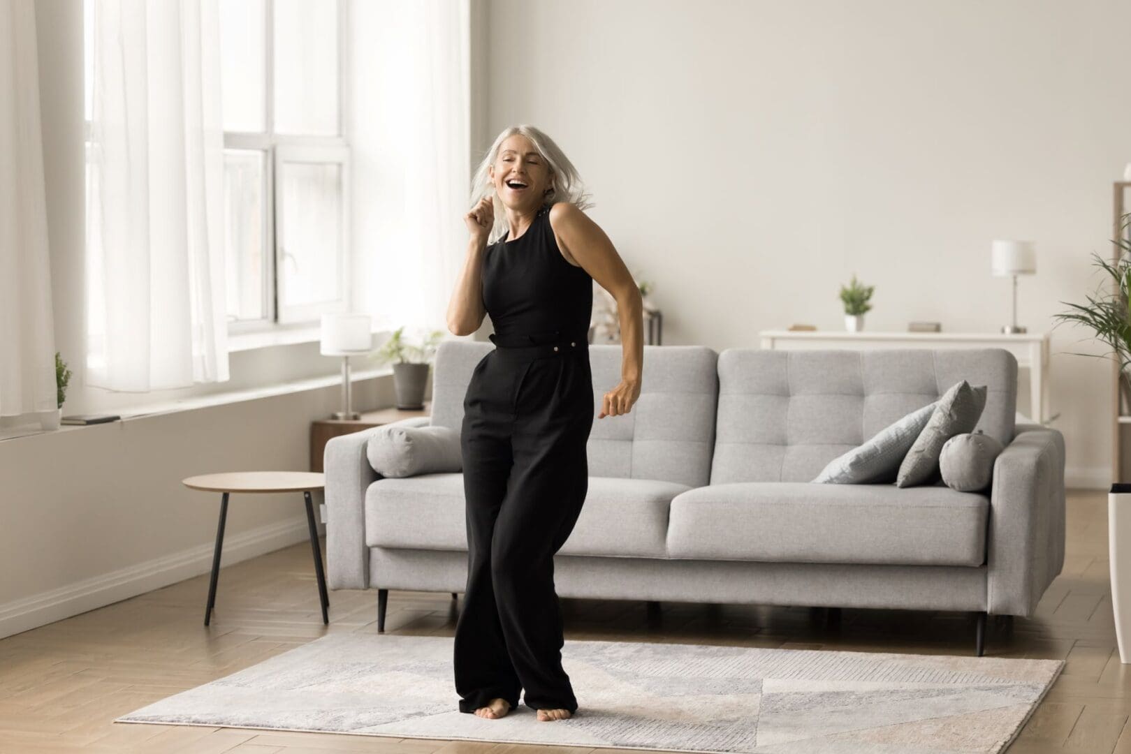 A woman in black dress standing on the floor.