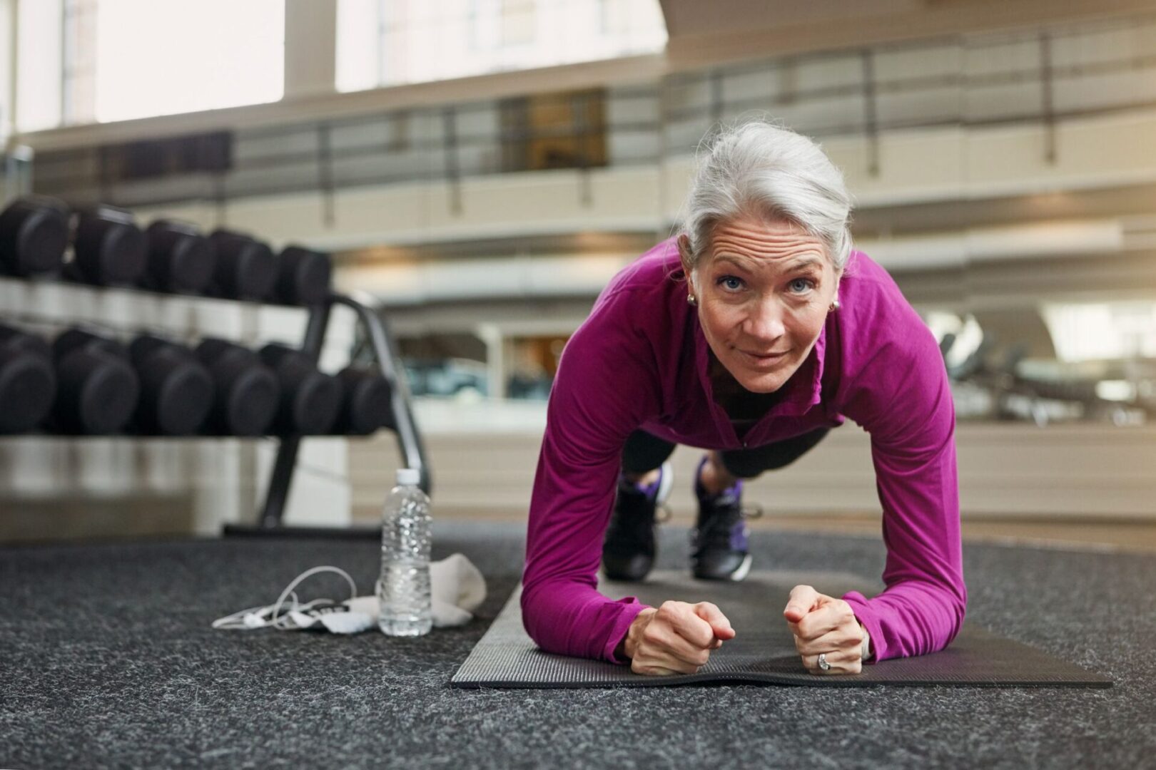 A woman is doing some yoga on the floor